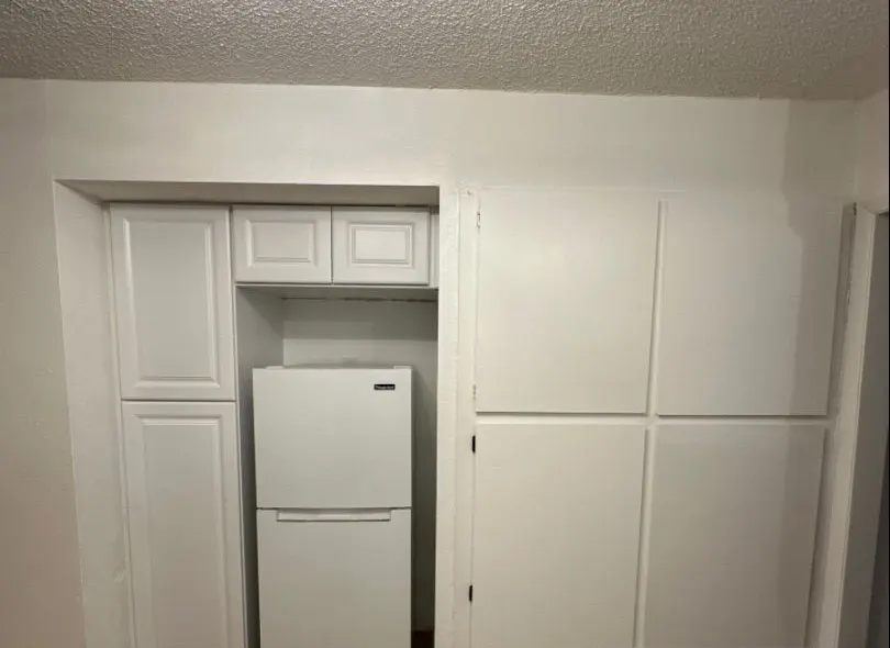 After: built-in storage. Broken shelving replaced with new cabinets and a fridge nook.