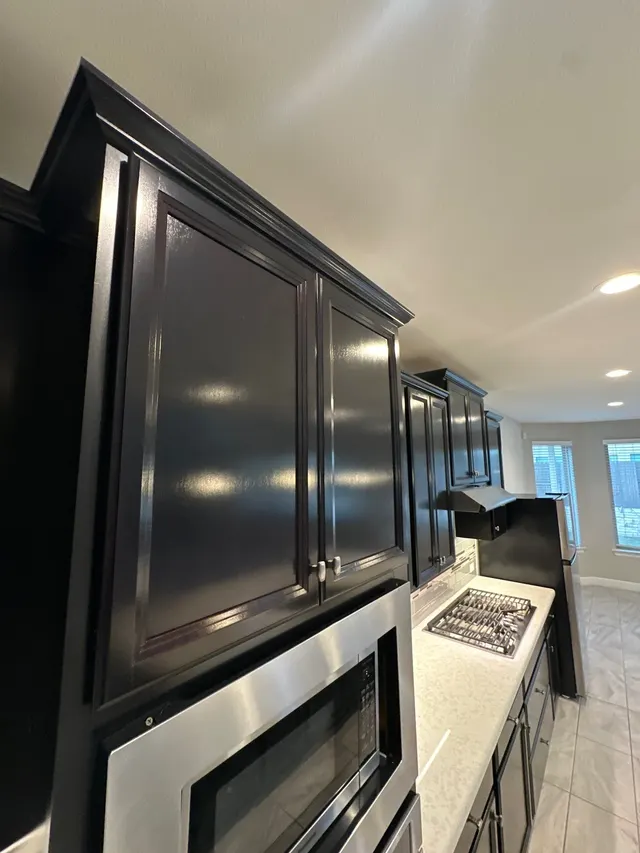 Painted black kitchen cabinets over a built-in microwave