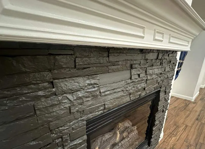 After: fireplace update. Dated stacked stone painted charcoal, mantel refinished in gloss white.