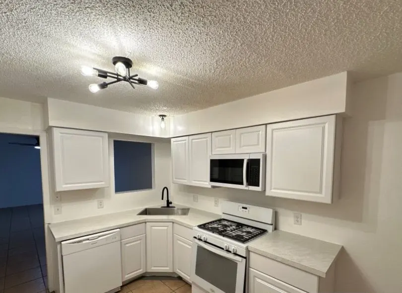 After: kitchen makeready. Cabinets, counters, sink, faucet and lighting brought back to rent-ready.
