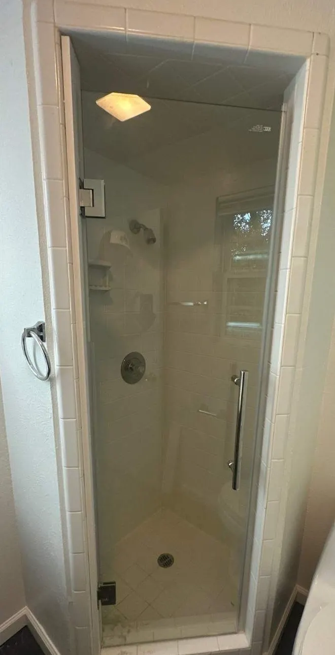After: frameless shower door. Open stall finished with a frameless glass door and new trim.